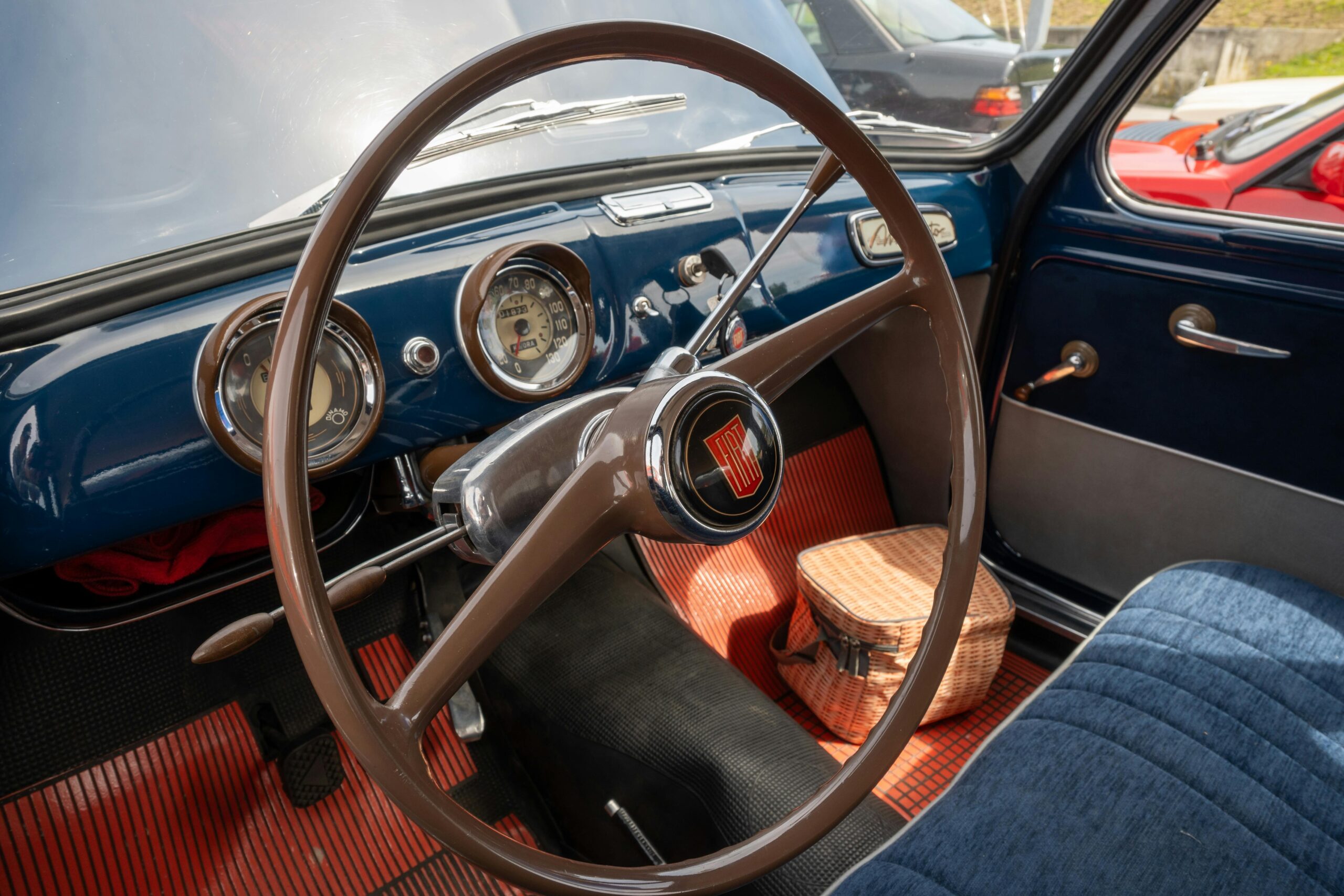 Explore the vintage charm of a Fiat 1100 interior, showcasing a classic steering wheel and retro dashboard design.
